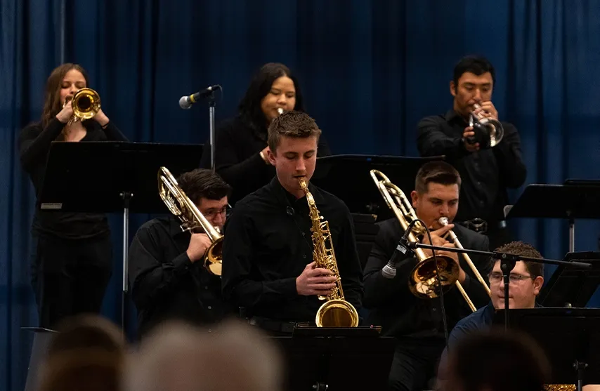 A group of students dressed in black perform a jazz concert on stage.